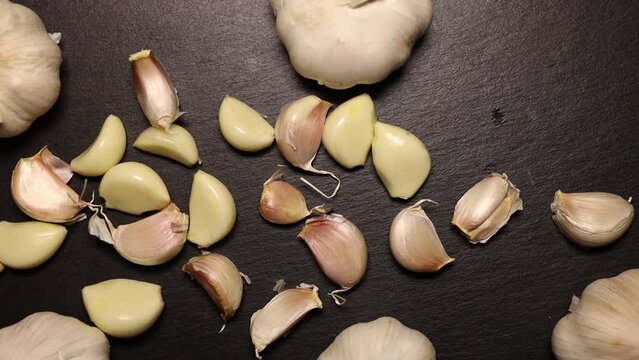 Ripe garlic on black stone plate. Raw garlic, bio vegetable for healthy lifestyle.