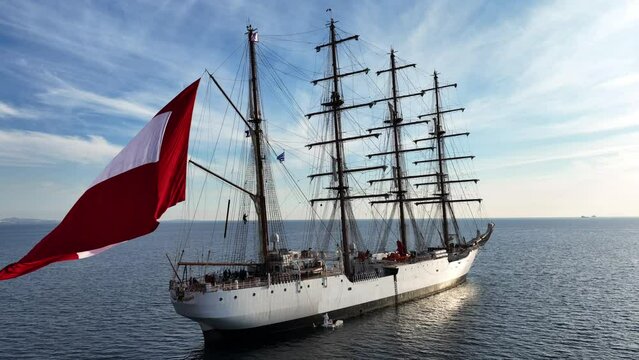 Aerial drone video of beautiful 3 mast barque or barc type classic sailing wooden boat anchored in Mediterranean deep blue sea