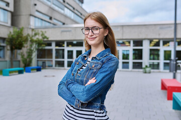 Portrait of teenage high school student girl with backpack, outdoor