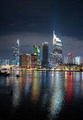 Ho Chi Minh City skyline and the Saigon River. Amazing colorful night view of skyscraper and other modern buildings at downtown. Travel concept