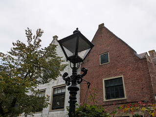 Fototapeta na wymiar Alkmaar schwarze Laterne zwischen zwei Häusern und einem Baum