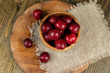 covered with drops of water ripe red cherries on the table