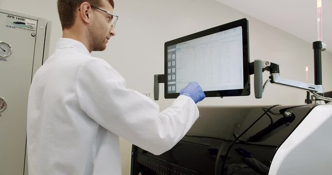 Blood Test Machine with tubes. A blood test with computer equipment. Blood Testing Machine Checks Samples In A Laboratory Room. Automated machine in work process, blood and urine sampleanalysis.