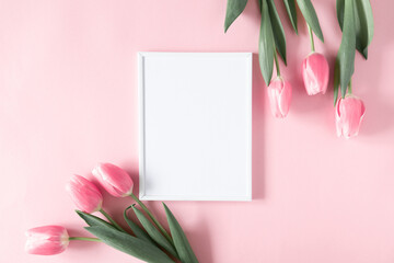 Flowers composition romantic. Flowers pink tulips, photo frame on pastel pink background. Wedding....