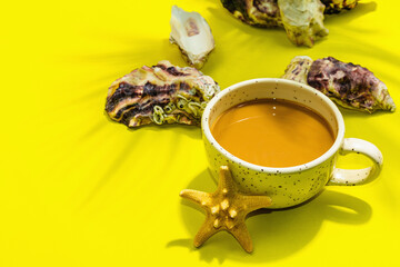 A cup of coffee in a marine style. Starfish, oysters, palm leaves. Hard light, dark shadow