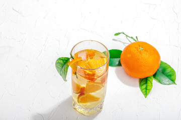 Orange cocktail with ice and ripe fruits. Refreshment seasonal drink, conceptual background