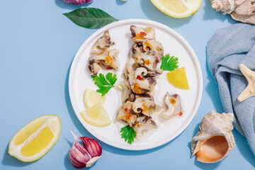 Pickled rapan meat with oil, spices and greens. Healthy seafood rich of omega