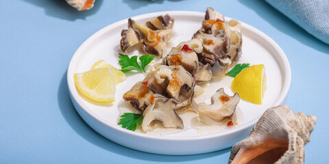 Pickled rapan meat with oil, spices and greens. Healthy seafood rich of omega