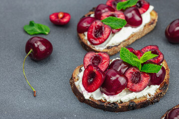 Fresh bread sandwiches with sweet cherry, cream cheese and mint leaves. Morning breakfast concept