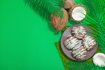 Profiteroles choux pastry buns with coconut cream served in tropical style. Palm leaves