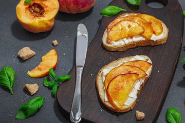 Fresh bread sandwiches with sweet peach slices, cream cheese and basil leaves. Good morning concept