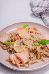 Plant based pasta with salmon, pesto and parmesan cheese. Ready to eat healthy food, served portion