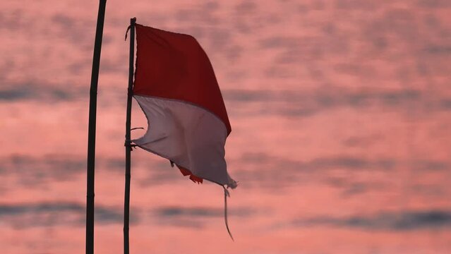 Indonesian flag fluttering in the wind against sunset background