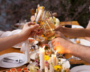 HAppy friends saying cheers and showing their champagne glasses full of sparkling wine to each...
