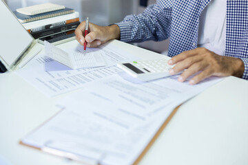 A man work at home calculate money in passbook use tablet and learning various documents about business and applying for loans to start new business