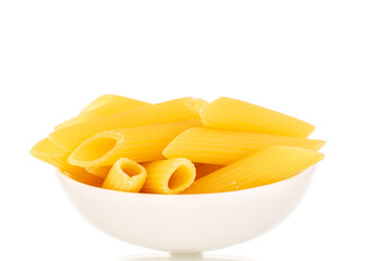 Uncooked pasta, penne, in a white ceramic plate, macro, isolated on white background.