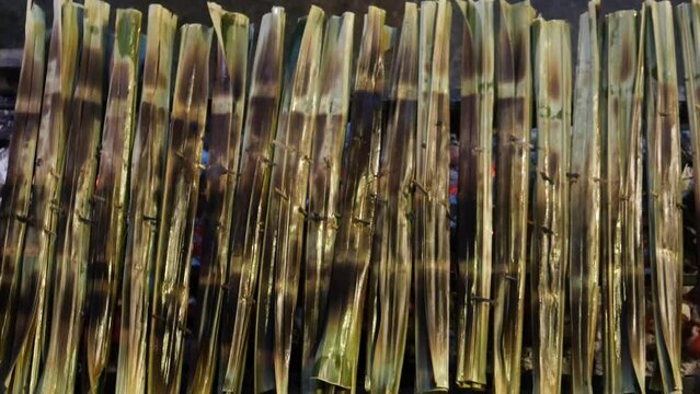 Thai sweetmeat made of flour, coconut and sugar and wrapped with nipa palm leaf (Kanom Chak). 