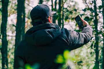 Persona sosteniendo un teléfono en un entorno de bosque. Conectando con la naturaleza y la tecnología