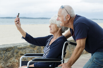Fototapeta premium senior couple in wheelchair taking selfies