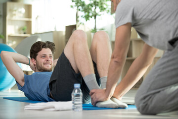 Naklejka premium young man practising yoga with experienced trainer