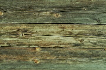 Fragment of an old natural wooden wall. The cracked wooden wall of an old building.