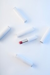 Lots of white lipsticks on light background. Cosmetics. View from above.