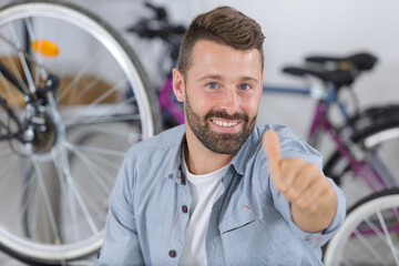 Fototapeta na wymiar smiling male selling in bicycle shop