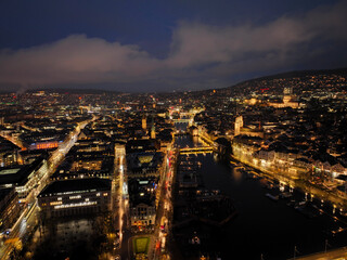 Fototapeta na wymiar Aerial view of Swiss City of Zürich with the old town, cityscape, skyline, Limmat River and city lights on a dark winter night. Photo taken January 5th, 2024, Zurich, Switzerland.