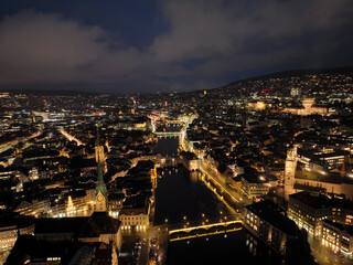 Aerial view of Swiss City of Zürich with the old town, cityscape, skyline, Limmat River and city lights on a dark winter night. Photo taken January 5th, 2024, Zurich, Switzerland.