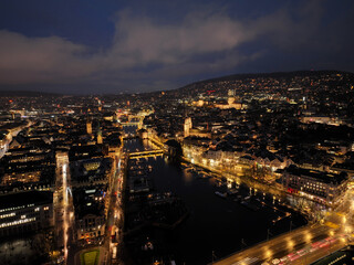 Aerial view of Swiss City of Zürich with cityscape, skyline, city lights, Limmat River and Lake Zürich on a dark winter night. Photo taken January 5th, 2024, Zurich, Switzerland.