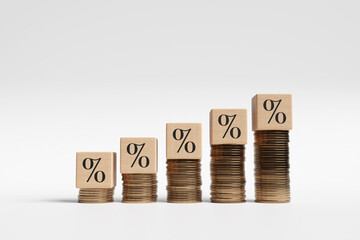 Wooden block having percentage sign on gold coin stacks in ascending order of height. Illustration of the concept of increasing interest rate