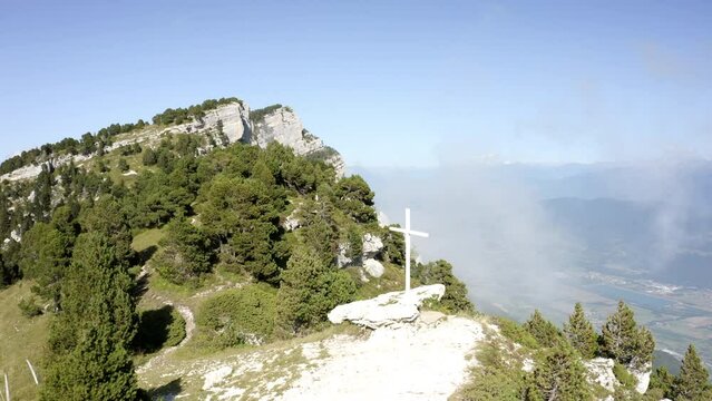 Aerial Forward Shot Of Cross Symbol On Top Of Tranquil Mountain During Sunny Day - Chambery, France