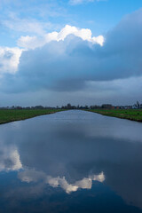 Tranquil view of clouds which are reflected in the calm waters of the Dutch polder landscape