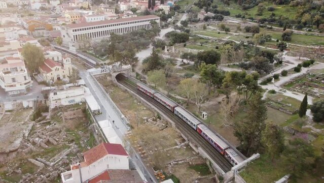 4k Aerial Acropolis and Agora Sunrise Athens with two metro trains passing