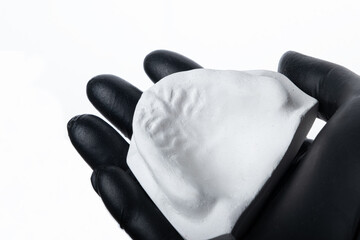 Anatomic upper cast on dentist hand. Selective focus.