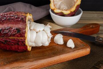 Delicious ripe cocoa fruit on cutting board. Selective focus.
