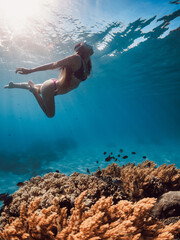 Woman swims underwater in tropical sea. Snorkeling in Hawaii