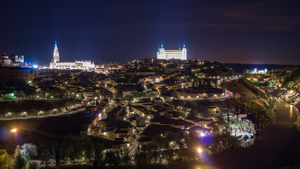 Die Altstadt von Toledo bei Nacht. Besonders beleuchtet ist Alcázar und Kathedrale. - obrazy, fototapety, plakaty