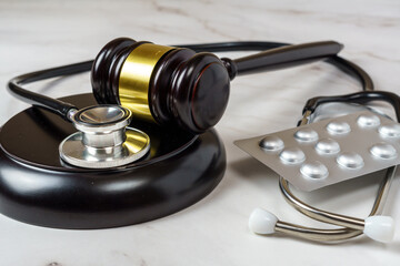 judge's gavel and a professional stethoscope representing legal decisions in health care. The...