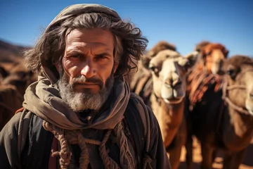 Fototapeten Berber man leading camel caravan. A man leads two camels through the desert. Man wearing traditional clothes on the desert sand, © Irina Mikhailichenko