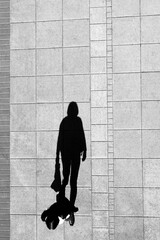 Shadow of a woman on city sidewalk
