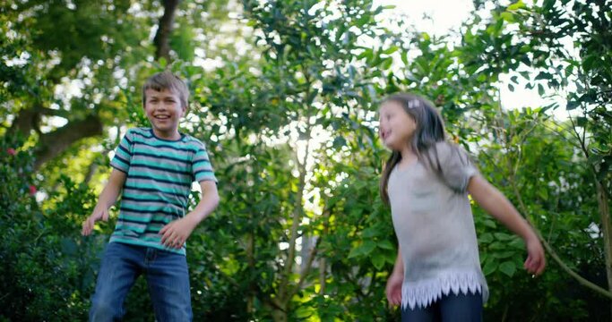 Trampoline, happy or kids jump in backyard for fun games on holiday vacation to relax together. Wellness, bounce or excited children in nature playing game or activity for freedom or energy in summer