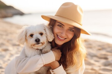 A woman and her adorable dog enjoy a sunset stroll on the beach, representing happiness and friendship.