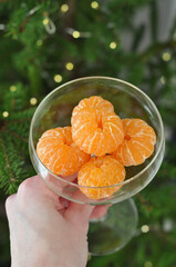 hand holding glass of tangerines