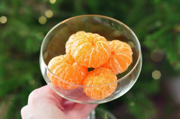 hand holding glass of tangerines