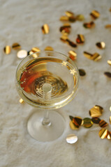 glass of champagne with gold confetti