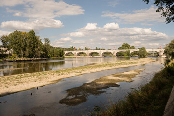 Pont Wilson bridge over diminished river Loire in rural France city Tours. fresh waterway has dried up significantly due to dry summer raised temperatures global warming - 703549266