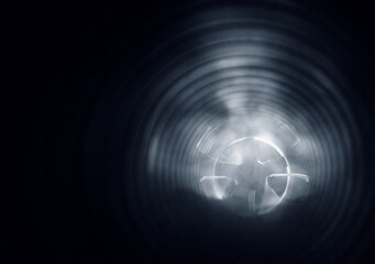 smoke in the ventilation duct of the air system of a shopping center, on a blurred background of the exhaust fan