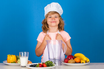 Cooking children. Chef kid boy making fresh vegetables for healthy eat. Portrait of little child in form of cook isolated on grey background. Kid chef. Cooking process.