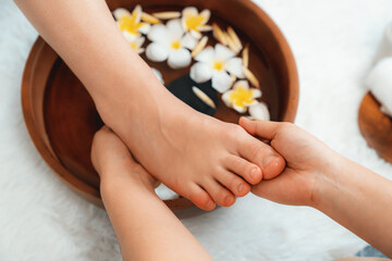 Woman indulges in blissful foot massage at luxurious spa salon while masseur give reflexology therapy in gentle day light ambiance resort or hotel foot spa. Quiescent - obrazy, fototapety, plakaty